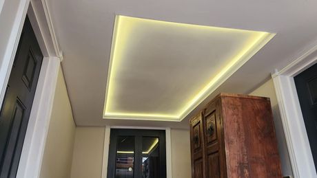 Bespoke ceiling with led lights attached within the cut out in the ceiling.