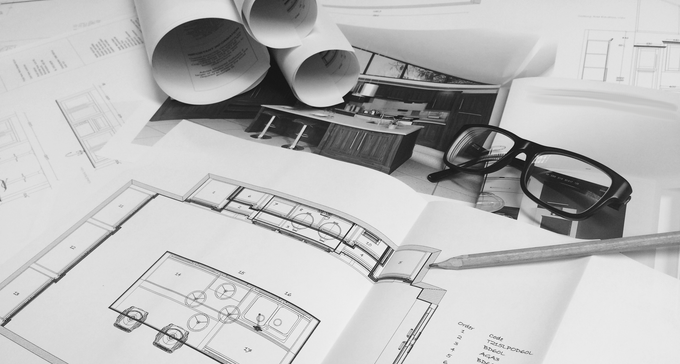 Image of plans and a pair of glasses on the table